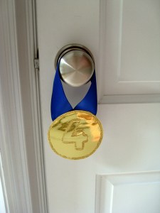 gymnastics party medal invitation hangs from doorknob